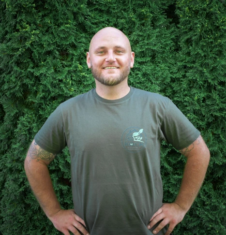 Hausmeister vor gepflegter Thuja-Hecke